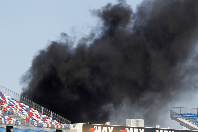Smoke billows from a fire at the Red Bull Air Race World Championship race at the Las Vegas Motor Speedway in Las Vegas on Sunday, Oct. 12, 2014. A firefighter was injured battling the blaze.(Just ...