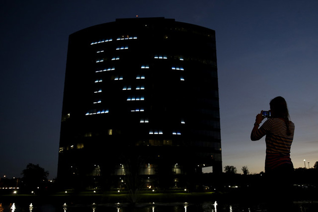Allison Corley takes a photo of an office building displaying the logo for the Kansas City Royals baseball team Thursday, Oct. 16, 2014, in the Kansas City suburb of Overland Park, Kan. (AP Photo/ ...