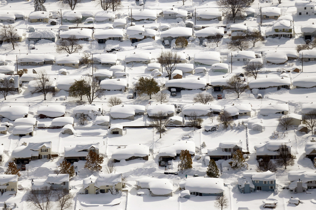 Homes are covered in snow in West Seneca, N.Y., Wednesday, Nov. 19, 2014. The Buffalo area found itself buried under as much as 7 feet of snow by Thursday. (AP Photo/The Buffalo News, Derek Gee)
