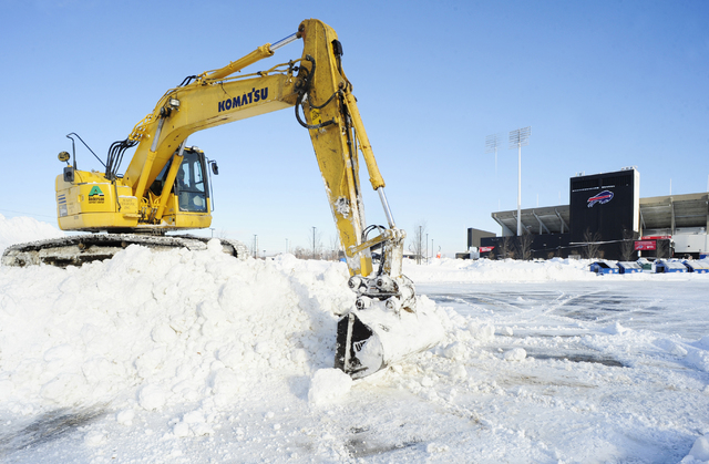 Work crews move snow in the parking lots outside Ralph Wilson Stadium in Orchard Park, N.Y., Friday, Nov. 21, 2014. Snowed out in Buffalo, the Bills are heading to Detroit to play their "home" NFL ...