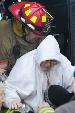 A firefighter from South Line lowers an elderly patient as she arrives to the Appletree Mall in Cheektowaga, N.Y., Thursday, Nov. 20, 2014. About 180 patients from the facility were moved after of ...