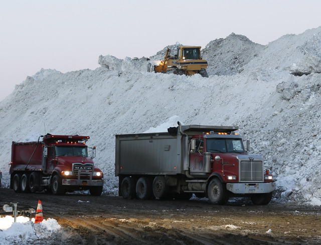 Dump trucks wait to unload snow at the Central Terminal that was removed from south Buffalo neighborhoods after heavy lake-effect snowstorms on Friday, Nov. 21, 2014, in Buffalo, N.Y. A snowfall t ...