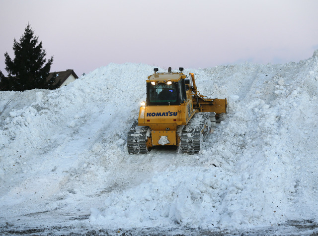 Heavy equipment moves snow at the Central Terminal that was removed from south Buffalo neighborhoods after heavy lake-effect snowstorms on Friday, Nov. 21, 2014, in Buffalo, N.Y.  A snowfall that  ...