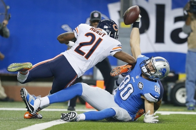 Detroit Lions tight end Joseph Fauria (80), defended by Chicago Bears strong safety Ryan Mundy (21) holds up the ball after his 8-yard reception during the second half of an NFL football game in D ...