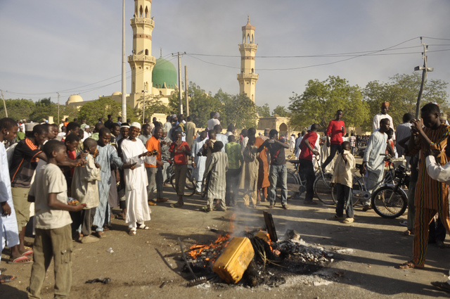 People gather at the site of a bomb explosion in Kano, Nigeria, Friday Nov. 28, 2014. An explosion tore through the central mosque in Nigeria's second-largest city on Friday, and officials feared ...