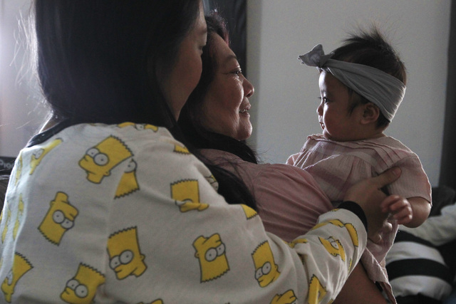 Bianka Santos watches as Lolita Dravin holds her granddaughter Olivia Santos Wednesday, Nov. 19, 2014. (Sam Morris/Las Vegas Review-Journal)