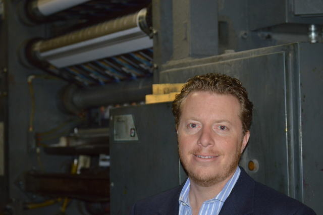 Allan Creel Jr., president of Creel Printing, stands in front of one of many presses at Creel Printing.
