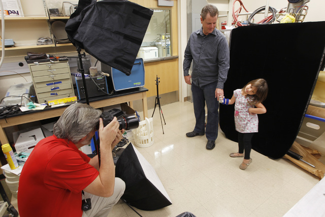 UNLV Photo Services photographer Aaron Mayes takes a photo of Greg Dawson and Hailey Dawson after Hailey was fitted with her new prosthetic hand Thursday, Oct. 30, 2014 at UNLV. (Sam Morris/Las Ve ...