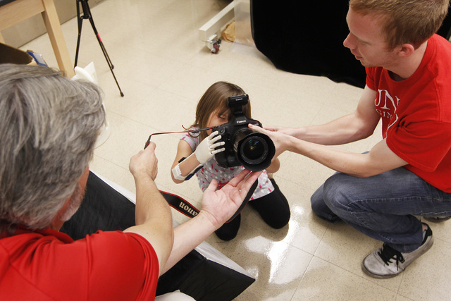 Hailey Dawson uses her new prosthetic hand to take a photo with UNLV Photo Services photographer Aaron Mayes' camera Thursday, Oct. 30, 2014 at UNLV. (Sam Morris/Las Vegas Review-Journal)