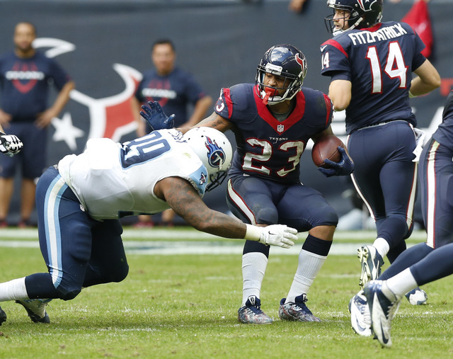 Nov 30, 2014; Houston, TX, USA; Houston Texans running back Arian Foster (23) runs with that ball against Tennessee Titans defensive tackle Jurrel Casey (99) at NRG Stadium. (Matthew Emmons-USA TO ...