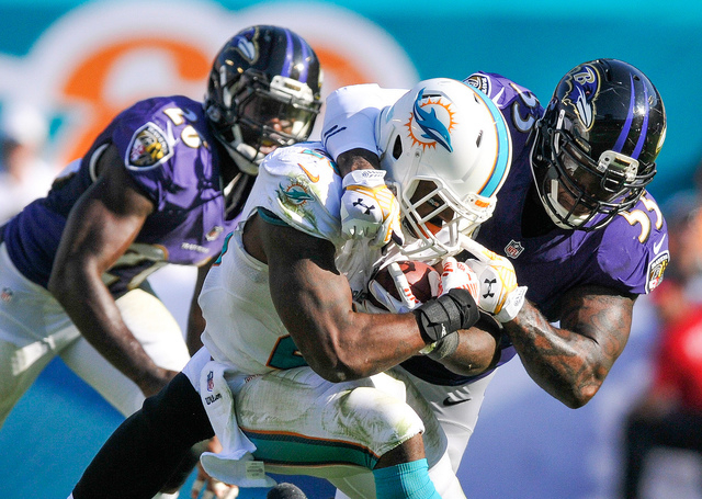 AFC North: Baltimore Ravens -- Outside linebacker Terrell Suggs (55) tackles Miami Dolphins running back Lamar Miller (26) in the second half of a game at Sun Life Stadium on Dec. 7, 2014. (Brad B ...