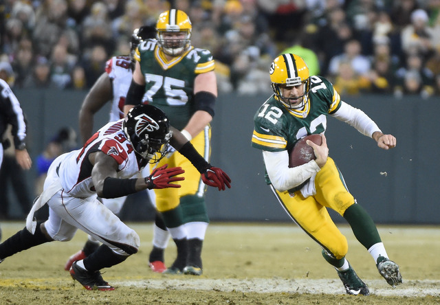 NFC North: Green Bay Packers -- Quarterback Aaron Rodgers (12) scrambles for a first down against Atlanta Falcons linebacker Jonathan Massaquoi (94) in the second quarter at Lambeau Field on Dec.  ...