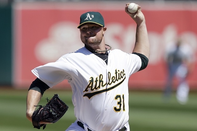 In this Sept. 3, 2014, file photo, Oakland Athletics pitcher Jon Lester throws against the Seattle Mariners during the first inning of a baseball game in Oakland, Calif. (AP Photo/Jeff Chiu, File)