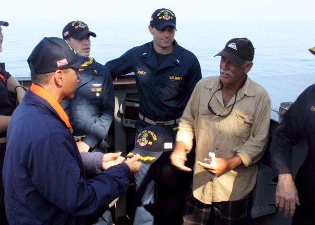 Cmdr. John Barsano, left, welcomes Ron Ingraham aboard the Arleigh Burke-class guided-missile destroyer USS Paul Hamilton (DDG 60) after rescuing him on Tuesday, Dec. 9, 2014, near Hawaii. Ingraha ...