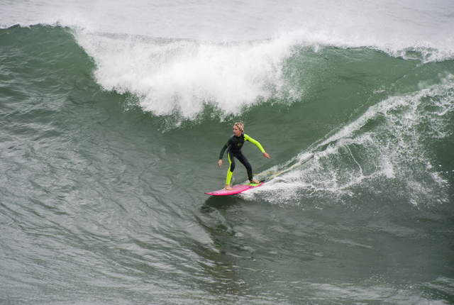 A young surfer catches one of the bigger waves in the morning in Huntington Beach on Thursday morning Dec. 11, 2014. A powerful storm churned down the West Coast on Thursday, bringing strong gales ...