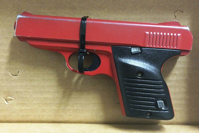 This photo provided by the Hamilton County  Sheriff in Cincinnati shows a red-painted, 380-caliber handgun police found during the arrest of 23-year-old Orlando Lowery when responding to a call ab ...