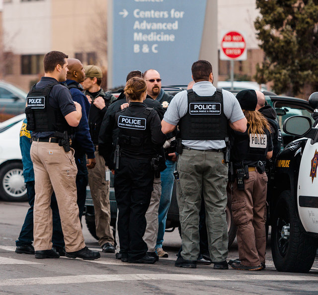 Officers gather in front of Renown Regional Medical Center on Tuesday in Reno after a gunman shot and killed a doctor and wounded two people before killing himself. (AP Photo/Scott Sady)