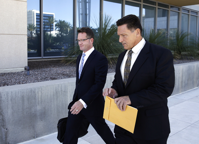 Suspended Las Vegas area family court judge Steven Jones, right, walks out of federal court with his attorney Robert Draskovich Wednesday, Sept. 17, 2014, in Las Vegas. Jones pleaded guilty to one ...