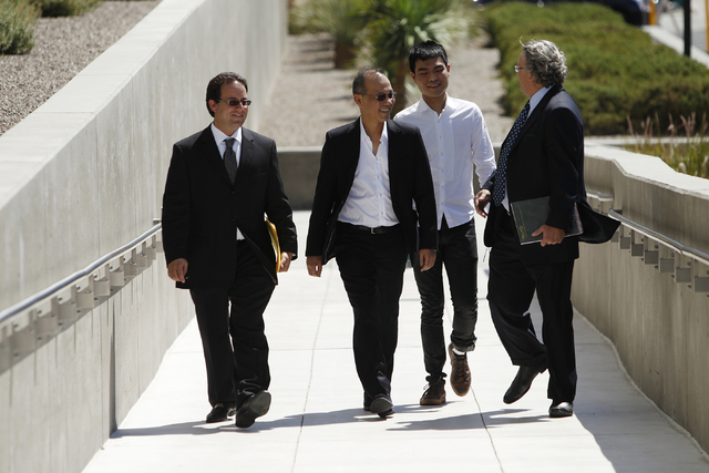 Paul Phua, second from left, and his son Darren, third from left, walk to Lloyd George Federal Courthouse in Las Vegas with their attorneys Richard Schonfeld, left, and David Chesnoff, for their a ...