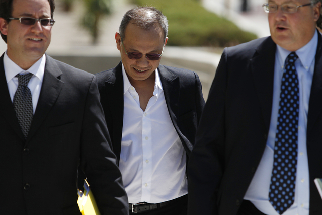 Paul Phua, center, walks to Lloyd George Federal Courthouse in Las Vegas with his attorneys Richard Schonfeld, left, and David Chesnoff, for his arraignment Tuesday, Aug. 5, 2014. Phua is accused  ...