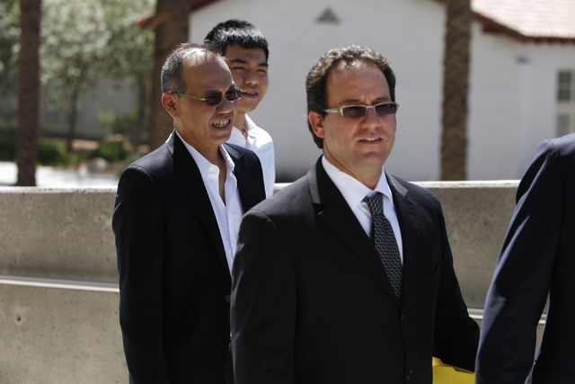 Paul Phua, left, and his son Darren, center, walk to Lloyd George Federal Courthouse in Las Vegas with their attorneys Richard Schonfeld, left, and David Chesnoff, not in the picture, for their ar ...