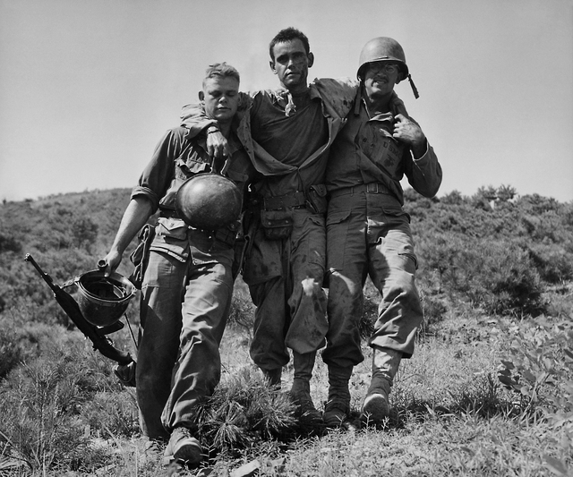FILE - In August 1950 file photo, U.S. Marines help a wounded buddy on the Naktong River front in South Korea. The war that began in Korea 60 years ago, on June 25, 1950, a ghastly conflict that ...