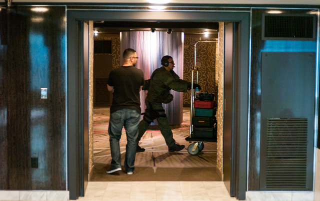 Las Vegas police and SWAT officers move equipment off of a room floor after an armed person committed suicide in a hotel room at the MGM Grand hotel-casino in Las Vegas on Wednesday, Dec. 10, 2014 ...