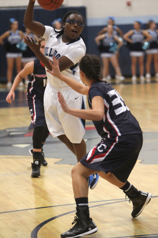 Centennial guard Tanjanae Wells passes over Coronado guard Taylor Tyrell in the second quarter of a basketball game at Centennial High School in Las Vegas on Wednesday, Dec. 3, 2014. Centennial wo ...