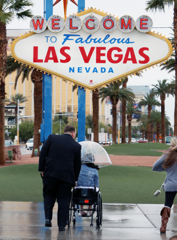 Andrew Lee, left, pushes his fiance Betty, both of Seattle, as they prepare to pose for photo, prior to their weeding ceremony, in front of the iconic "Welcome to Fabulous Las Vegas" sig ...