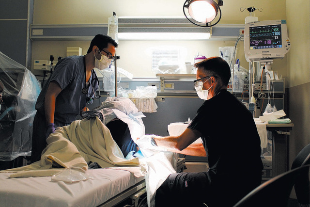Dr. J.D. McCourt, right, tends to a patient at University Medical Center, where he is medical director of the hospital's Adult Emergency Department. Diagnosis of a kidney stone can take one to two ...