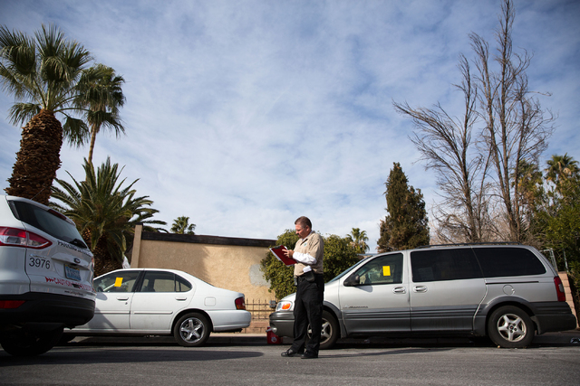 Craig Campbell starts an abandoned vehicle complaint and issues a ticket for an unregistered vehicle on two vehicles parked on Fulton Place on Friday, Jan. 16, 2015. (Samantha Clemens-Kerbs/Las Ve ...