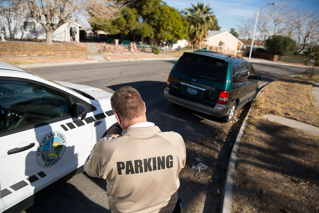 Craig Campbell checks the registration on a van, which a neighbor complained had been sitting idle for months, on Thelma Lane Friday, Jan. 16, 2015. (Samantha Clemens-Kerbs/Las Vegas Review-Journal)