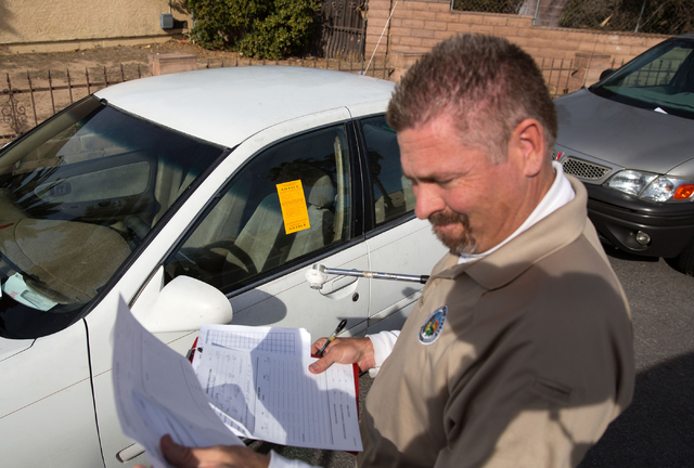 Craig Campbell starts an abandoned vehicle complaint and issues a ticket for an unregistered vehicle on Fulton Place on Friday, Jan. 16, 2015. (Samantha Clemens-Kerbs/Las Vegas Review-Journal)