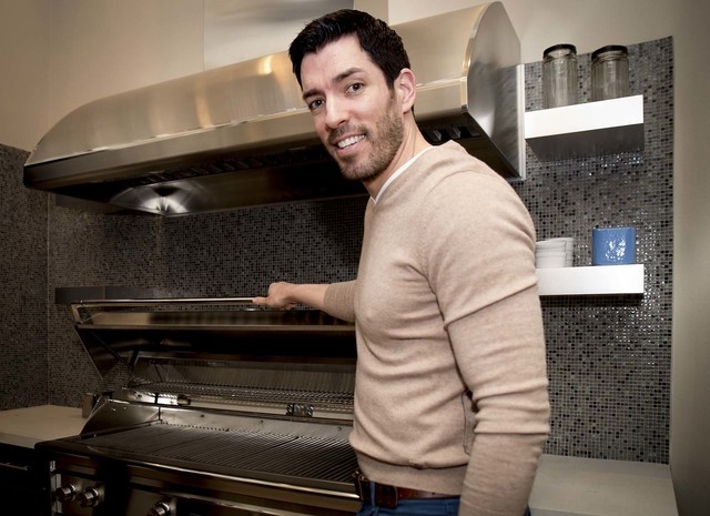 Drew Scott shows of a grill large enough to hold 35 steaks. (Tonya Harvey/Real Estate Millions)