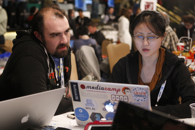 Matthew Young, left, and Serena Xu, members of the Personal Black Box team, work at their station during the 2015 AT&T Hackathon competition at the Palms casino-hotel in Las Vegas Sunday, Jan. 4,  ...