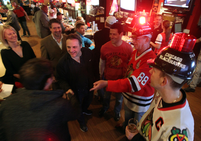 Gavin Maloof, center, shakes hands with Mike McHugh, left, at Brando's Sports Bar at 3725 Blue Diamond Road in Las Vegas during a watch party for the Chicago Blackhawks-Los Angeles Kings NHL hocke ...