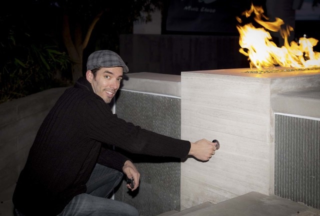 Jonathan Scott shows off the fire feature in the home's pool area. (Tonya Harvey/Real Estate Millions)