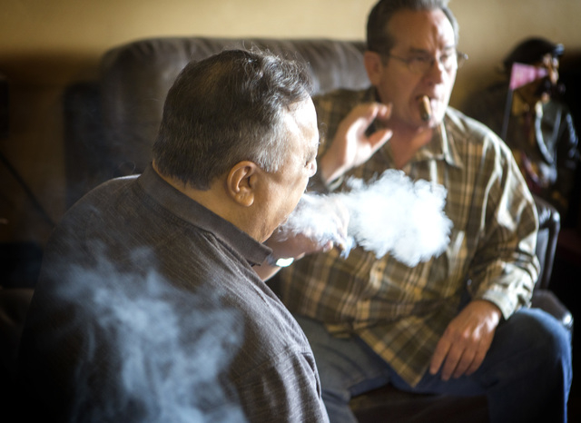 Customers Joe Fallico, left, and Dave Moretti  smoke cigars at En Fuego Cigars & Lounge, 328 West Sahara Avenue, on Wednesday, Jan. 28, 2015. Gov. Brian Sandoval is proposing to raise taxes on tob ...