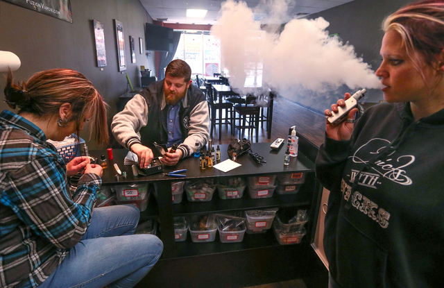 From left, Shelly McCurdy, Justin McClelland and Nina McIntosh smoke e-cigarettes at Nevada Vapor Supply in Carson City, Nev., on Tuesday, Jan. 27, 2015. Cigarette taxes and regulations on e-cigar ...