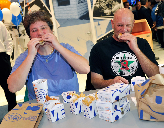 Linda Kitchel, left, and her friend Newman (no last name given) take their first bite of a White Castle burger during the grand opening of White Castle's newest and only location west of the Rocky ...