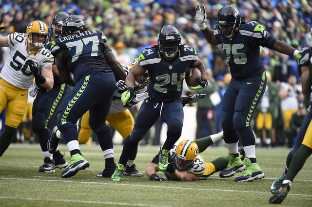 Seattle Seahawks running back Marshawn Lynch (24) runs the ball ahead of  Green Bay Packers outside linebacker Nick Perry (53) during the second half in the NFC Championship game at CenturyLink Fi ...