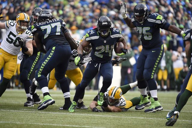 Seattle Seahawks running back Marshawn Lynch (24) runs the ball ahead of Green Bay Packers outside linebacker Nick Perry (53) during the second half in the NFC Championship game at CenturyLink Fi ...