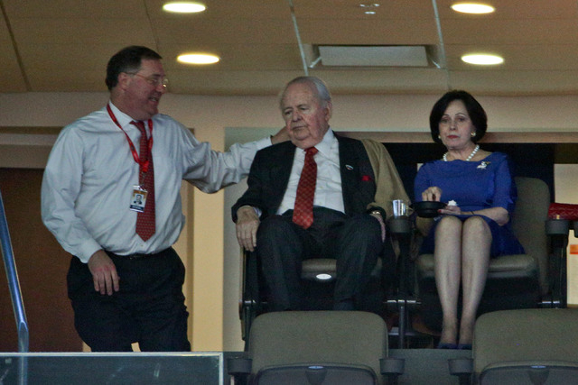 Jan 28, 2015; New Orleans, LA, USA; New Orleans Pelicans and New Orleans Saints owner Tom Benson and his wife Gayle Benson talk with team president Dennis Lauscha during the first quarter of a gam ...