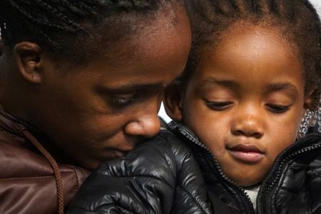 Akai Gurley's daughter Akaila sits on her mother Kimberly Ballinger's lap as Rev. Al Sharpton speaks at the National Action Network in Harlem, New York, Nov. 22, 2014. (Reuters/Carlo Allegri)