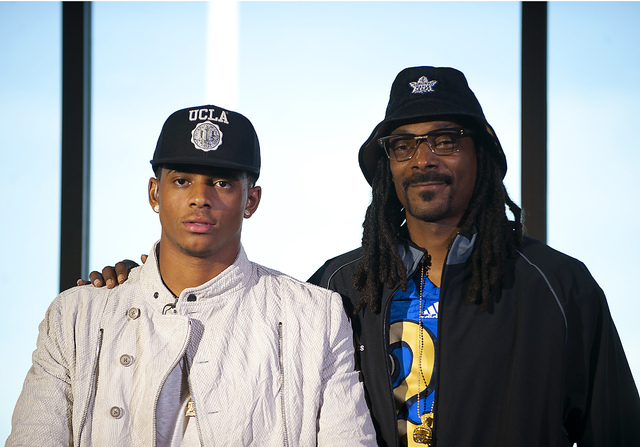 Recording artist Snoop Dogg stands beside his son Cordell Broadus who announced his commitme ...