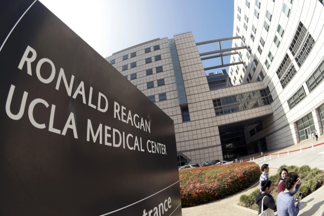 People walk past the entrance to the Ronald Reagan UCLA Medical Center in Los Angeles, Feb. 19, 2015. The large Los Angeles teaching hospital has told scores of patients they were possibly exposed ...