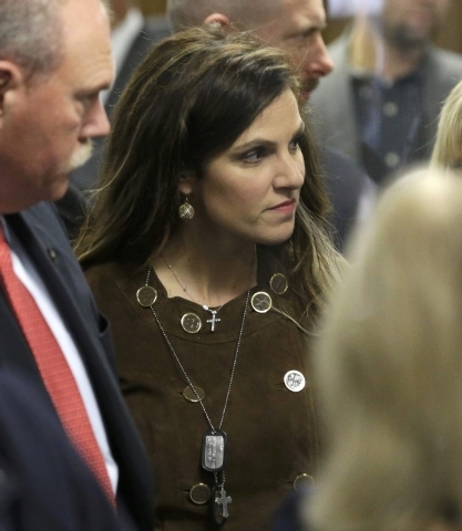 Taya Kyle, widow of former Navy SEAL Chris Kyle, wears her husband's military dog tags as she walks out of the courtroom during a break in the capital murder trial of former Marine Eddie Ray Routh ...