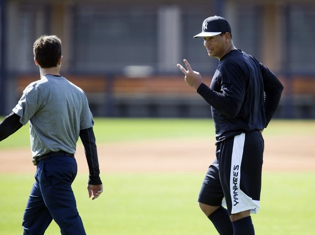 New York Yankees' Alex Rodriguez (R) talks with a trainer at the Yankees minor league complex for spring training in Tampa, Florida February 23, 2015.  (REUTERS/Scott Audette)