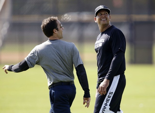 New York Yankees' Alex Rodriguez (R) looks up at a helicopter circling the Yankees minor league complex for spring training in Tampa, Florida February 23, 2015. (REUTERS/Scott Audette)