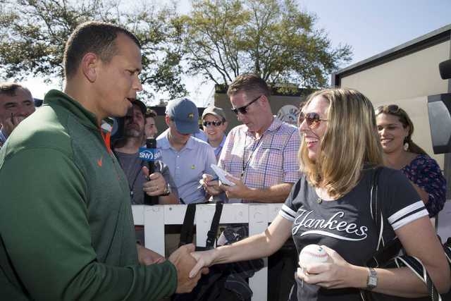 New York Yankees' Alex Rodriguez (L) greets a fan waiting for a autograph at the Yankees minor league complex for spring training in Tampa, Florida February 23, 2015. (REUTERS/Scott Audette)